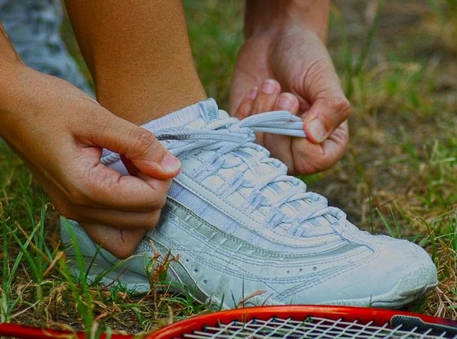 Tying Shoe Laces Ready For A Game Of Badminton