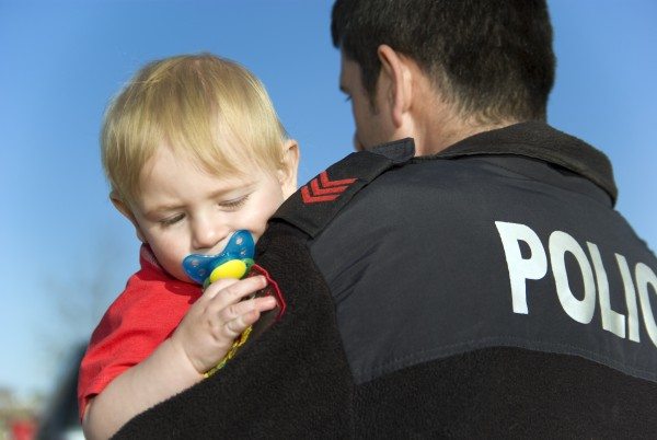 Police Officer protects and holds baby