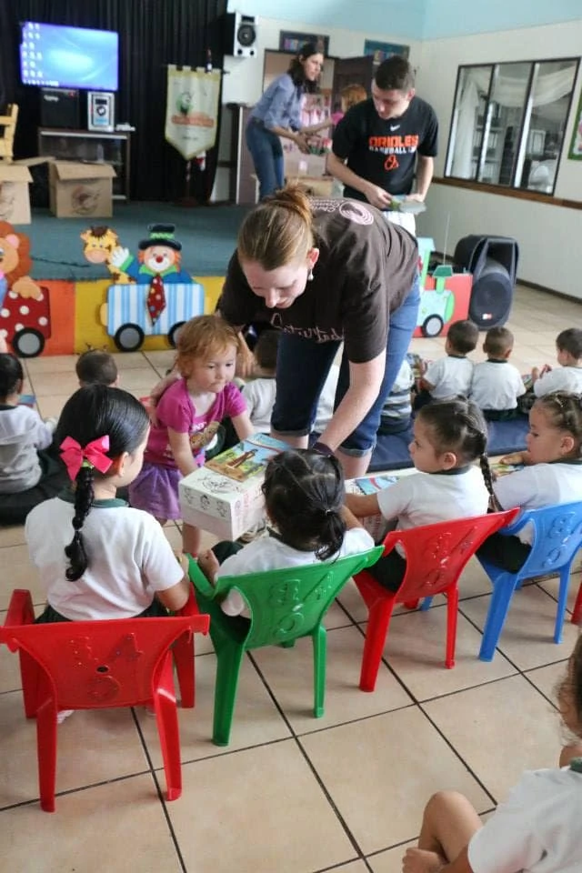 A child and mother handing out Operation Christmas Child shoeboxes to little girls in Costa Rica. 