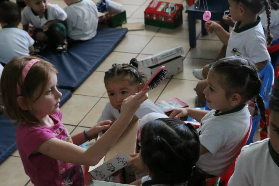 Little girls looking at a hairbrush that came out of an Operation Christmas Child shoebox. 