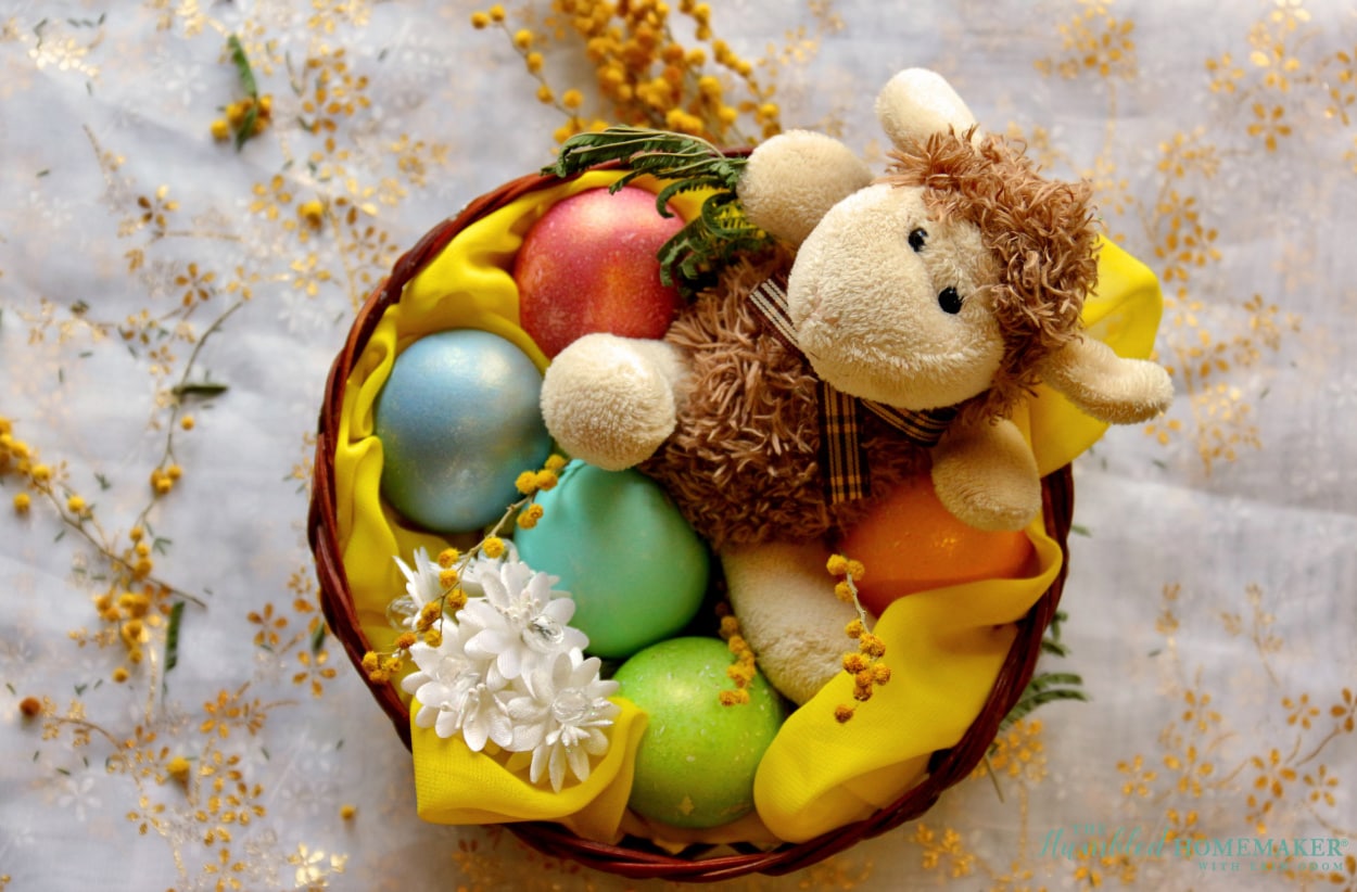 An Easter basket with colorful eggs and a stuffed animal.