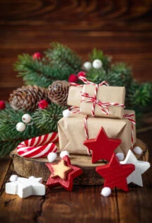 Christmas gifts wrapped in brown paper tied with red and white string, accompanied by festive decorations.