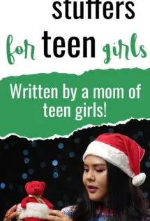 A teenager in a santa hat holding a teddy bear, showcasing stocking stuffers for teen girls.