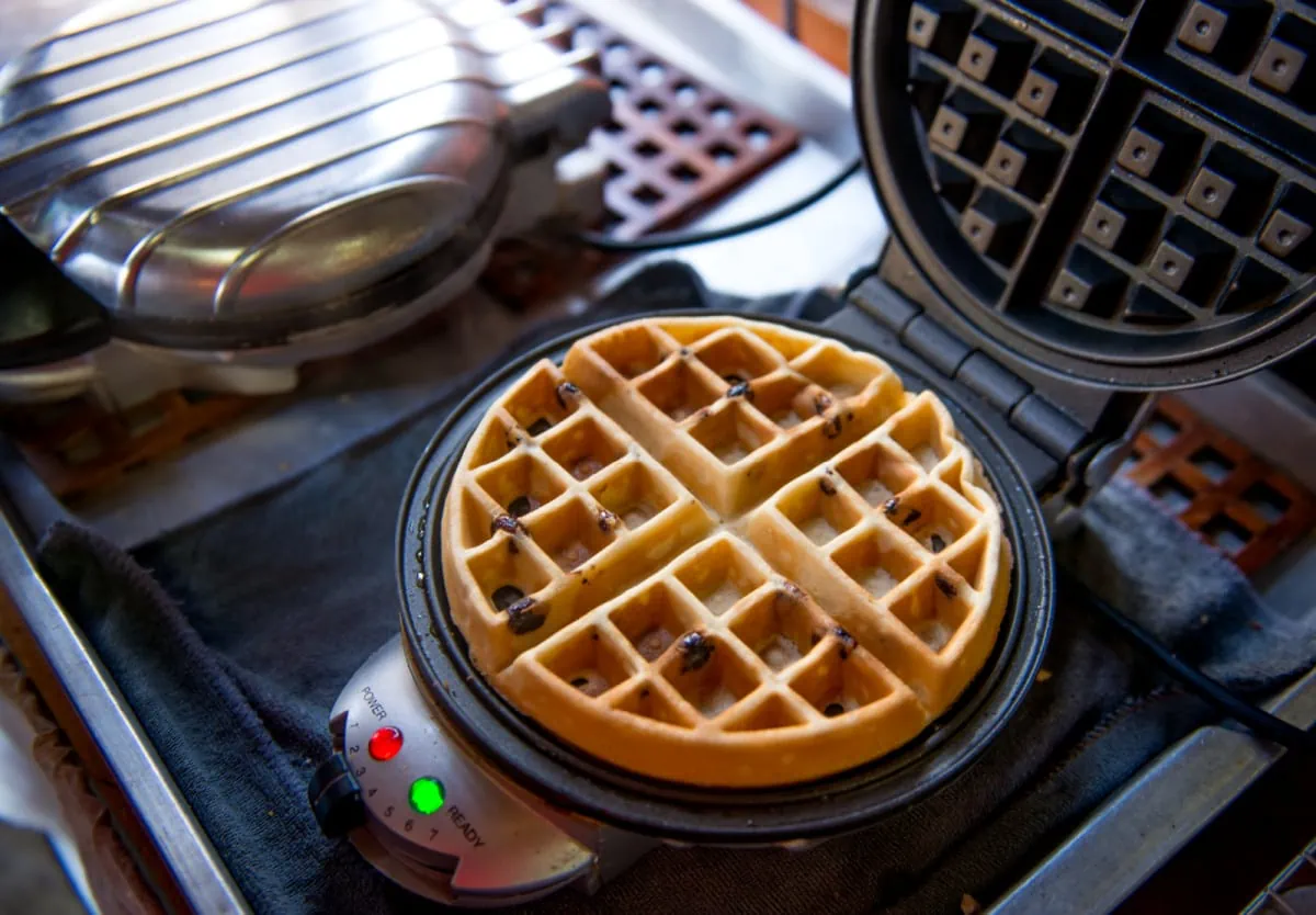 A waffle maker is being used to make waffles.