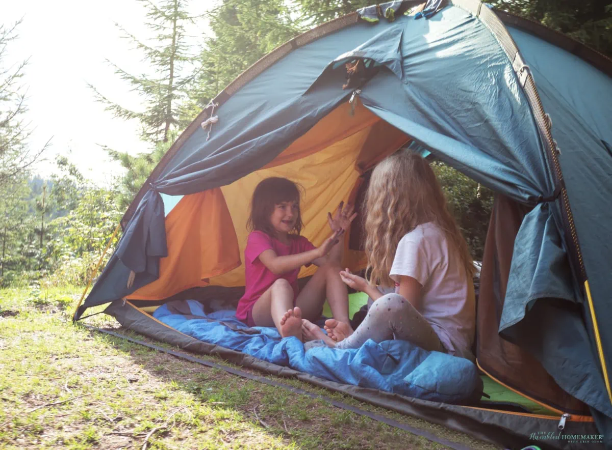 Two girls enjoying a staycation sitting in a tent.