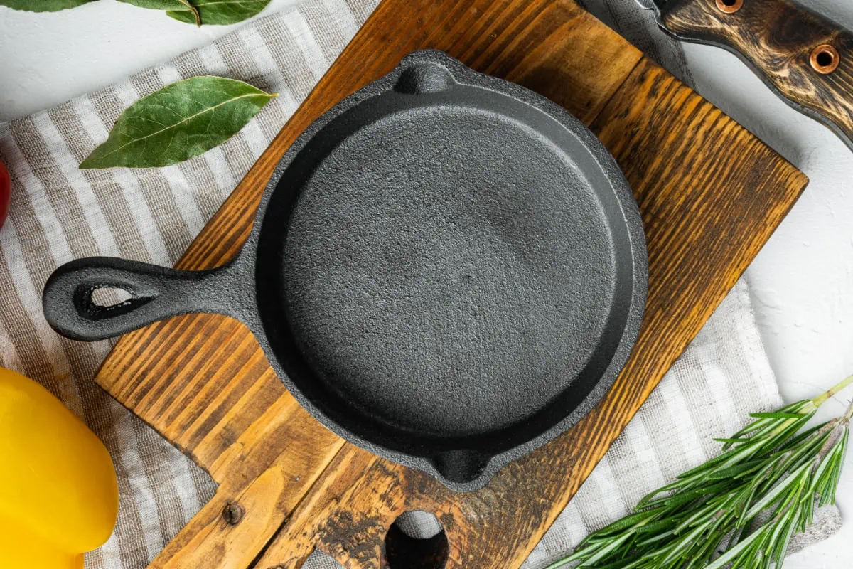A cast iron skillet on a wooden cutting board.