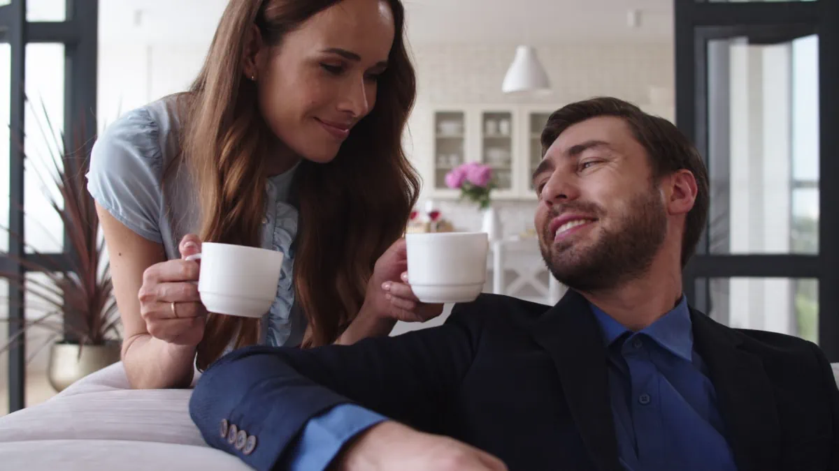 A man and woman are sitting on a couch, enjoying coffee from subscription boxes for men.