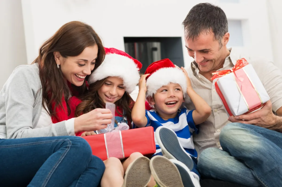 A family is sitting on the couch with simple Christmas presents.