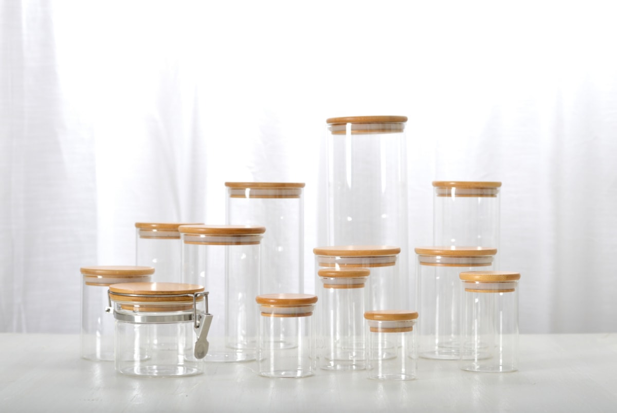 A group of glass jars with lids on a white table.