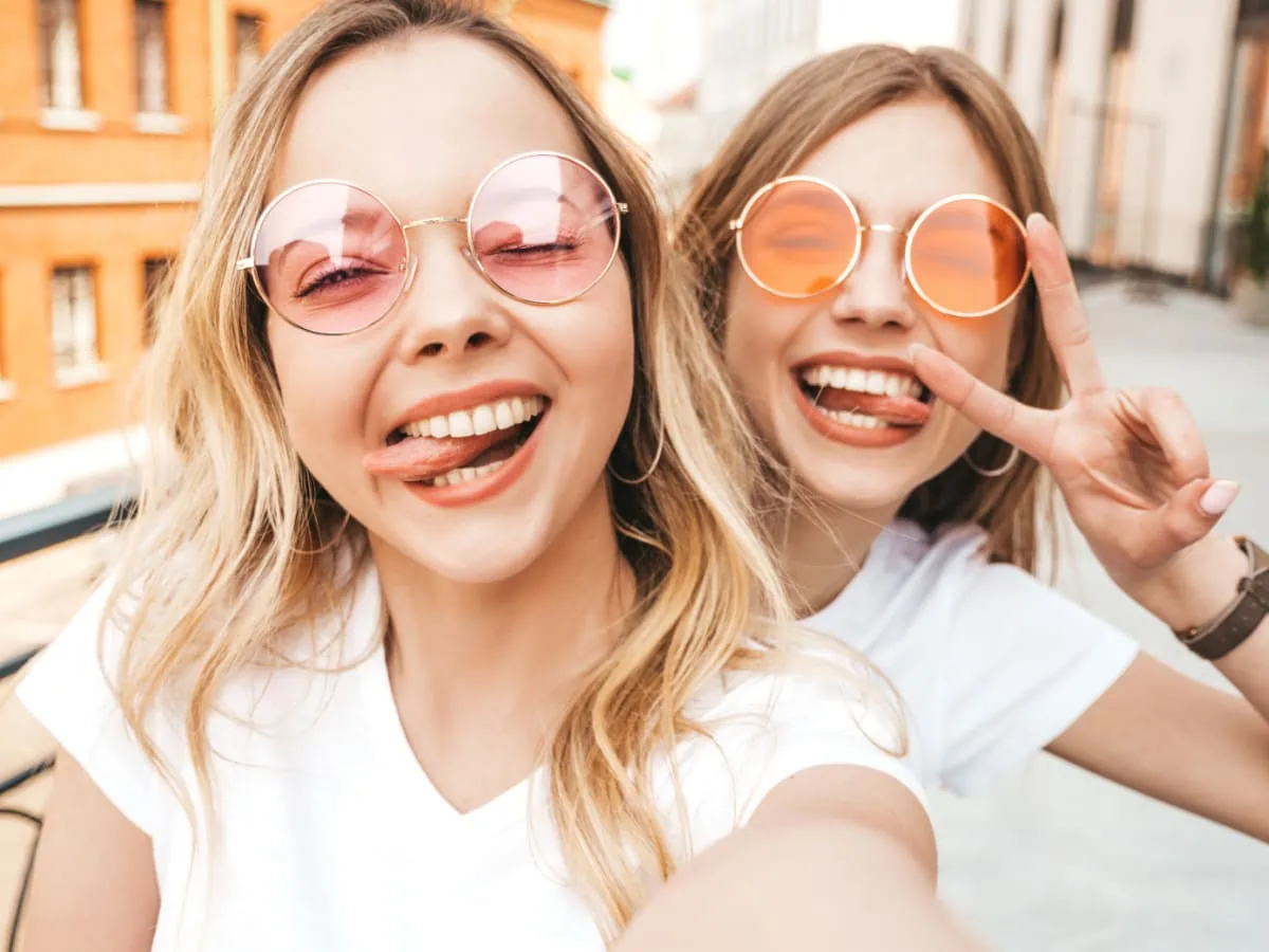 Two women in sunglasses taking a selfie.