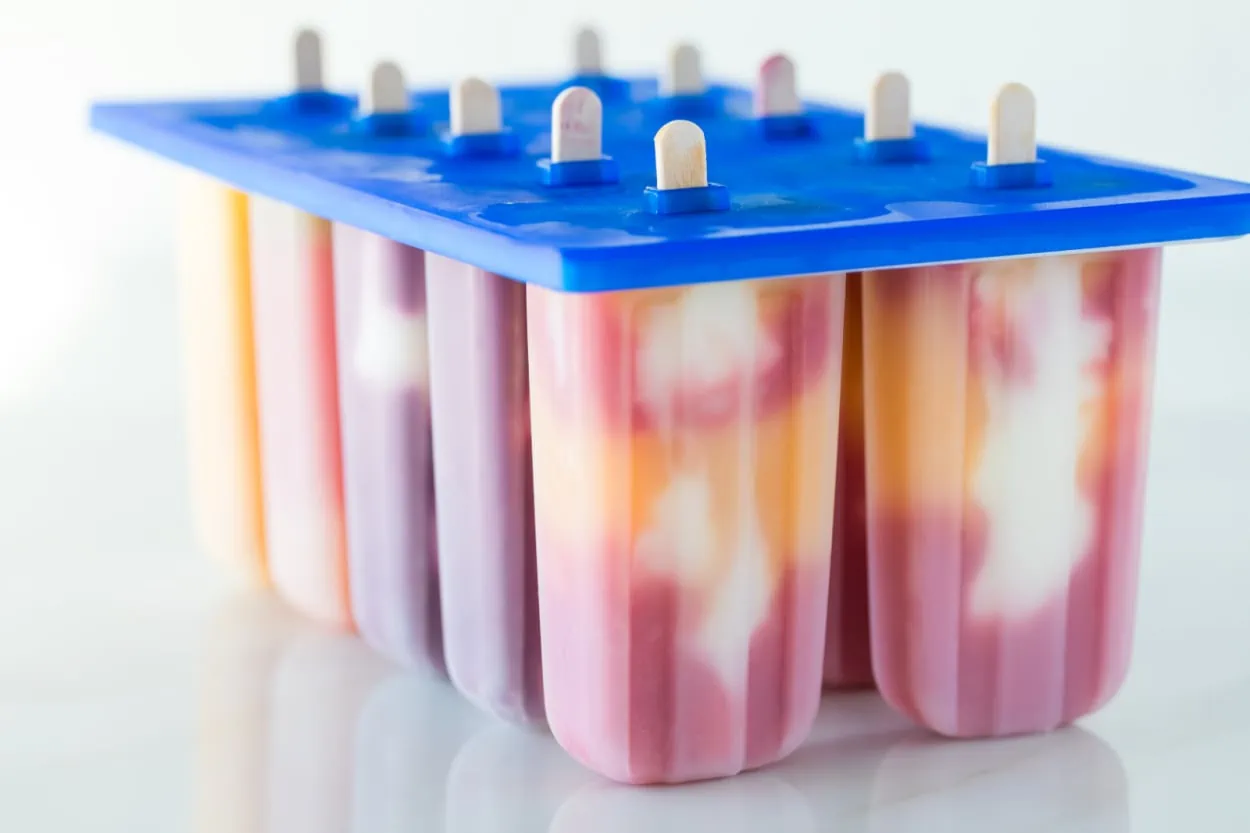 Colorful popsicles in a plastic container perfect for warm weather treats. These were made using leftover baby food purees.